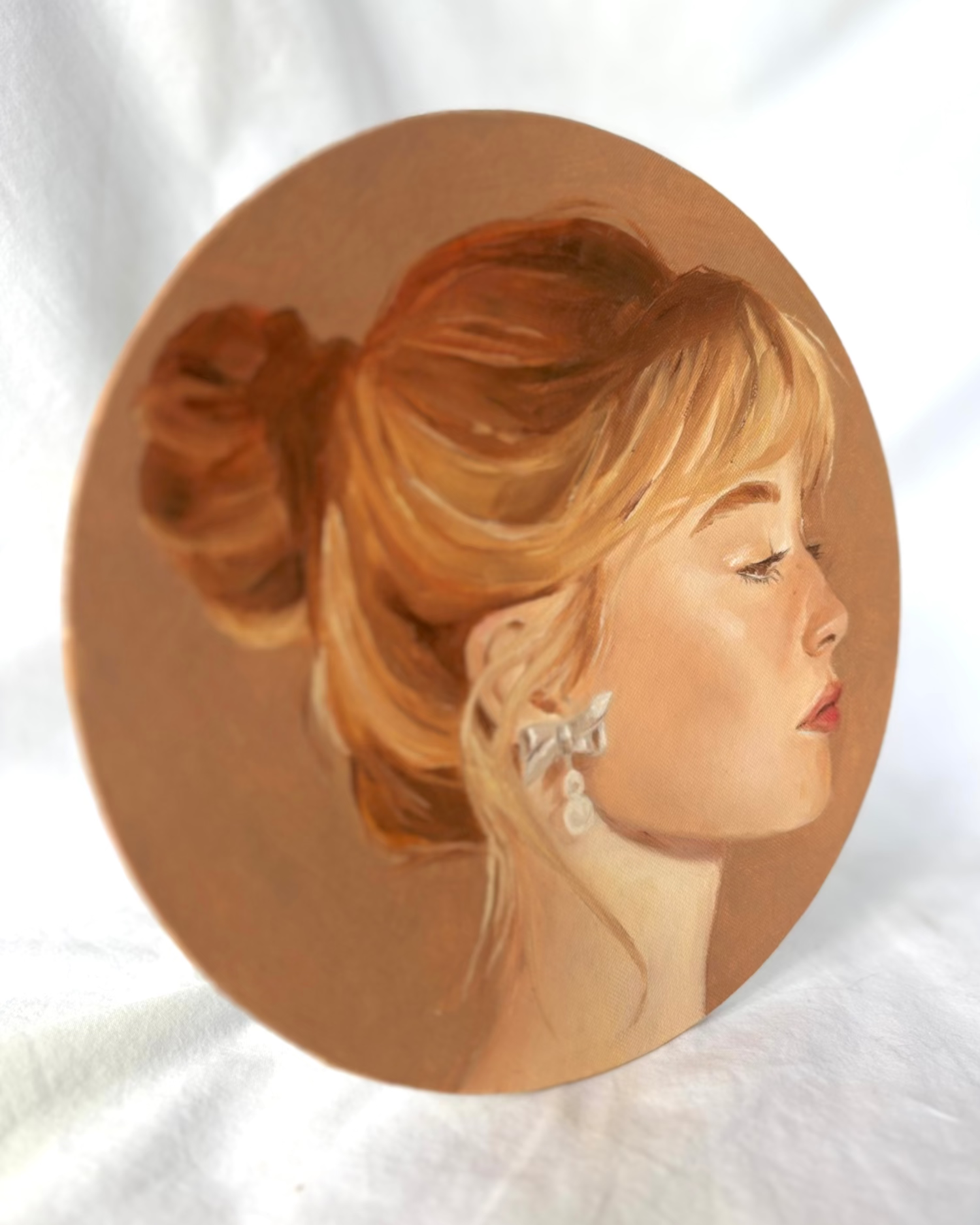 Circular portrait of a woman with ginger hair and a white background