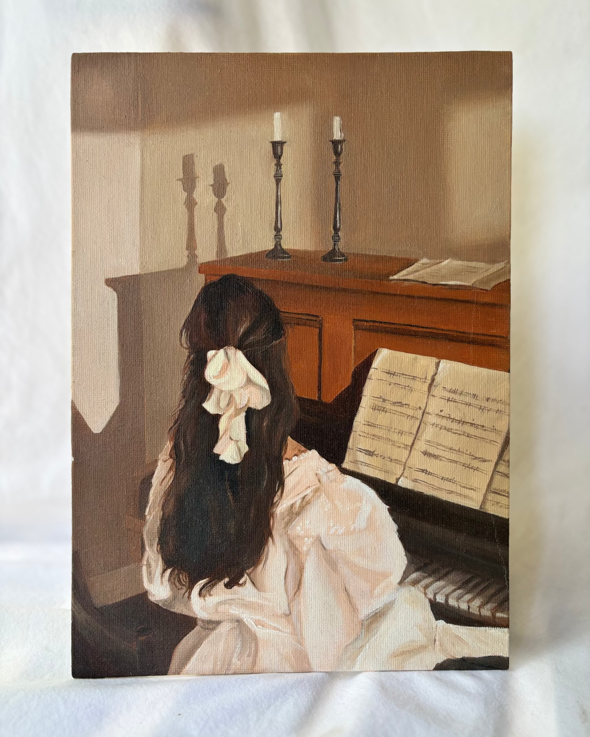 Woman sitting at a piano with candles in the background