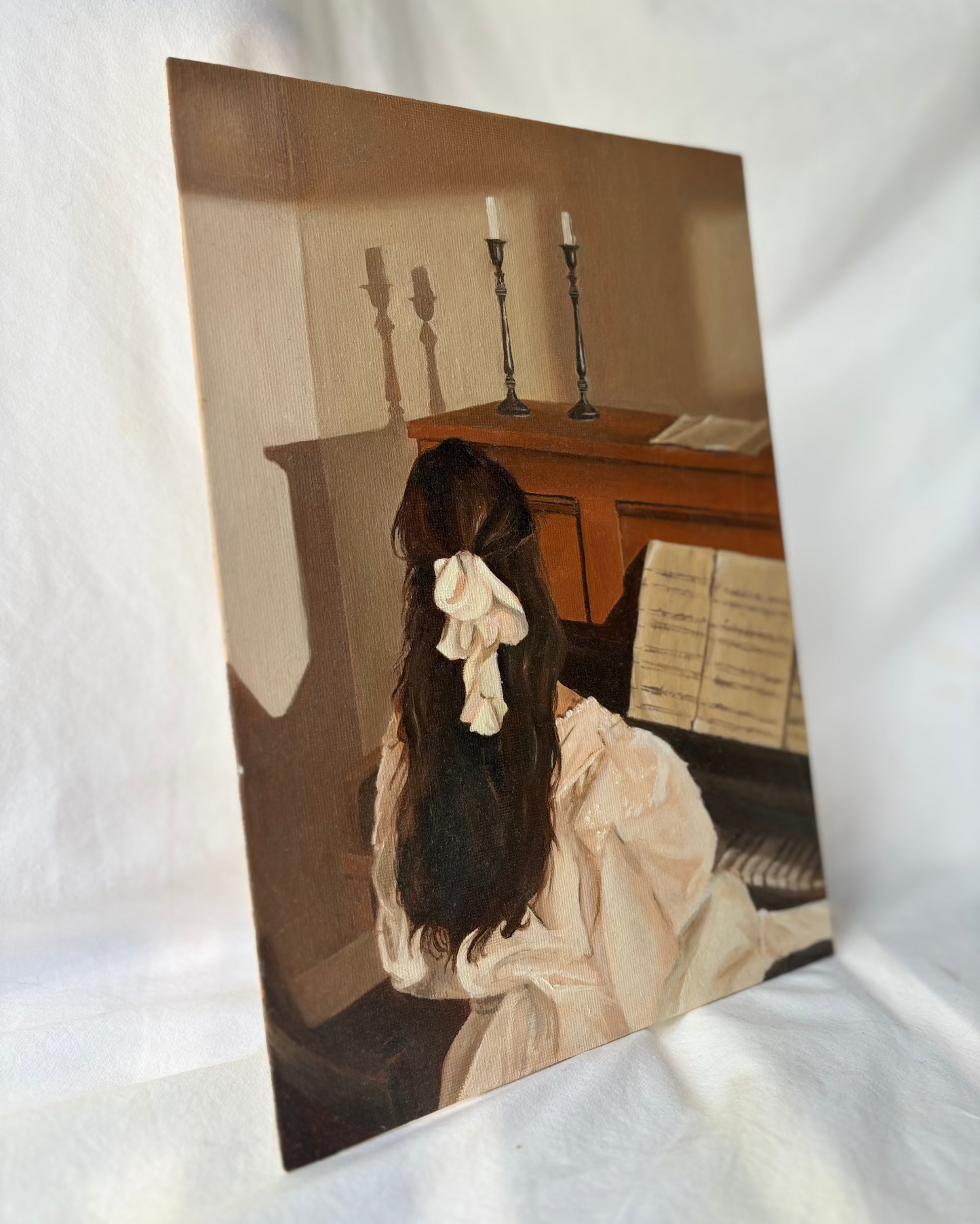 Artistic depiction of a woman sitting at a piano with candles in the background.